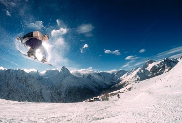 un snowborder faisant une figure sur une piste enneigée