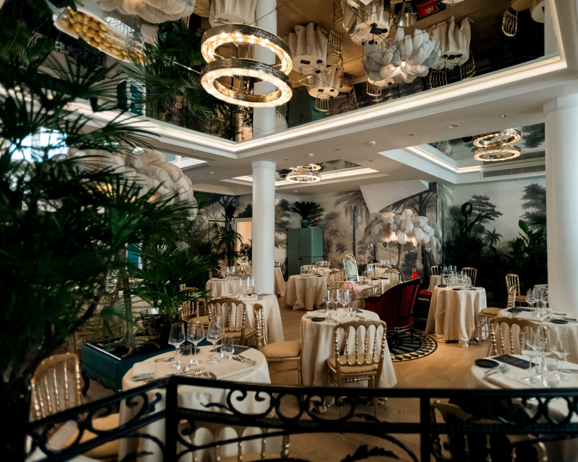 restaurant au sein de l'hôtel avec des chandelier un large espace des tables drapés de blanc et une argenterie luxueuse
