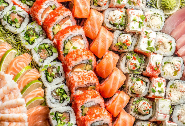 sushi au saumon (et au riz) maki sushi et tempura les uns à côtés des autres, à la chaîne