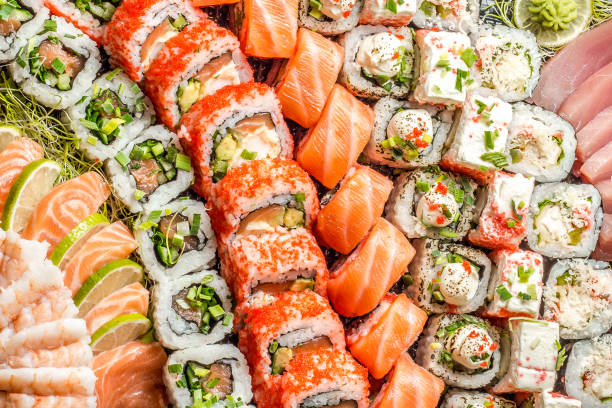 sushi au saumon (et au riz) maki sushi et tempura les uns à côtés des autres, à la chaîne