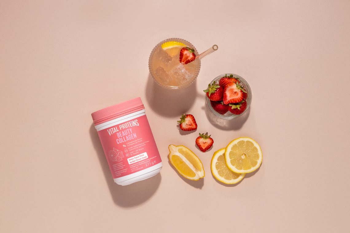 L'image montre un pot de "Vital Proteins Beauty Collagen" entouré de fraises et de tranches de citron, avec un verre de boisson rafraîchissante garnie de fruits.