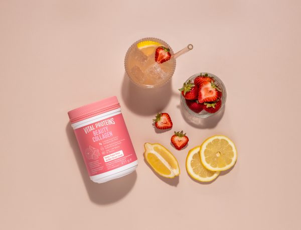 L'image montre un pot de "Vital Proteins Beauty Collagen" entouré de fraises et de tranches de citron, avec un verre de boisson rafraîchissante garnie de fruits.