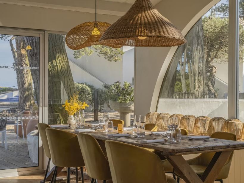 Face à la mer, une table de restaurant dressée.