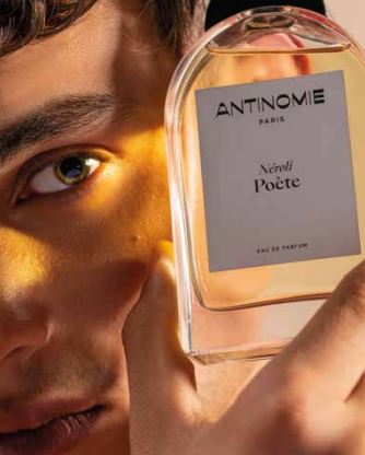 Homme qui tient une bouteille de parfum.