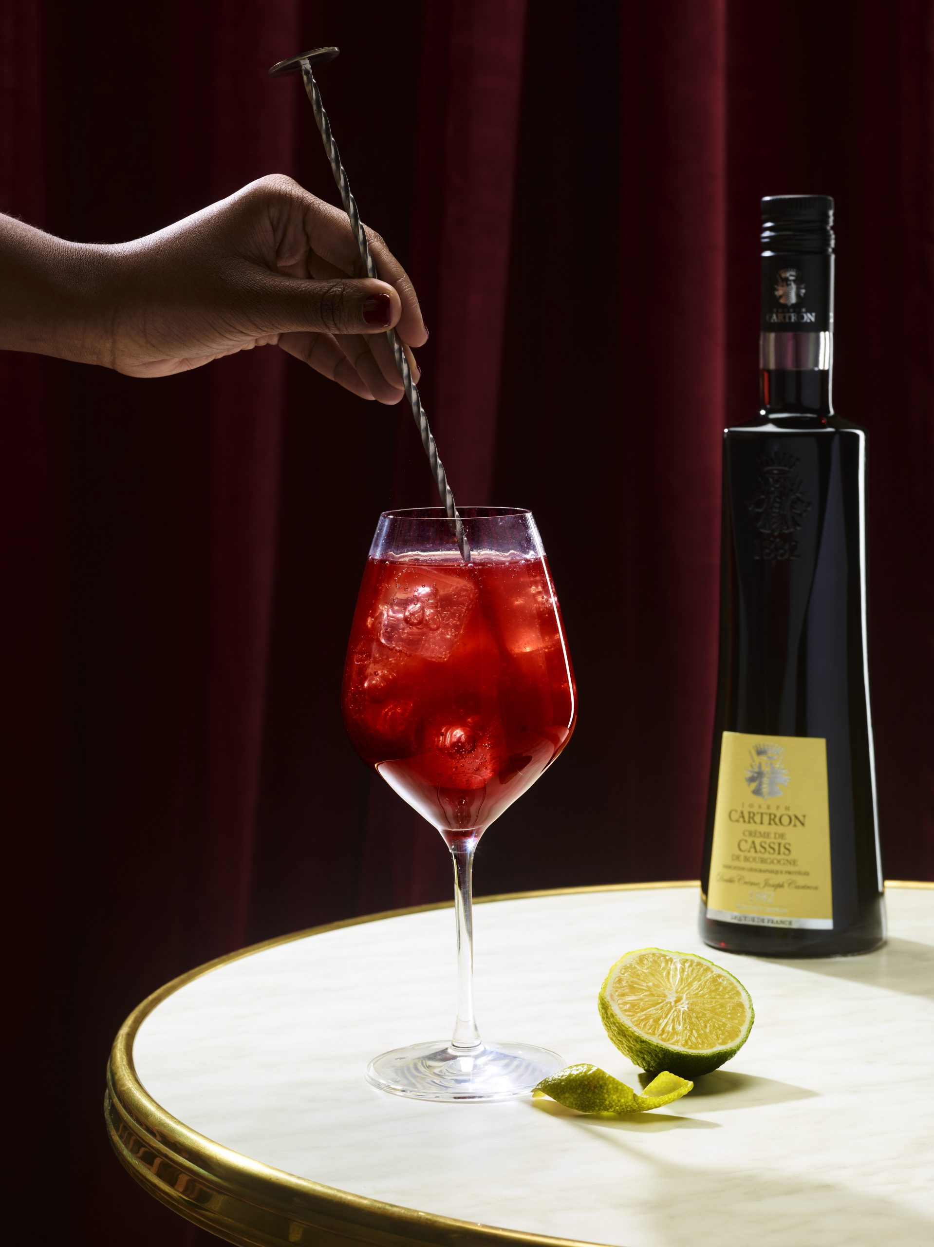 Cocktail en train d'être mélangé, sur fond noir.