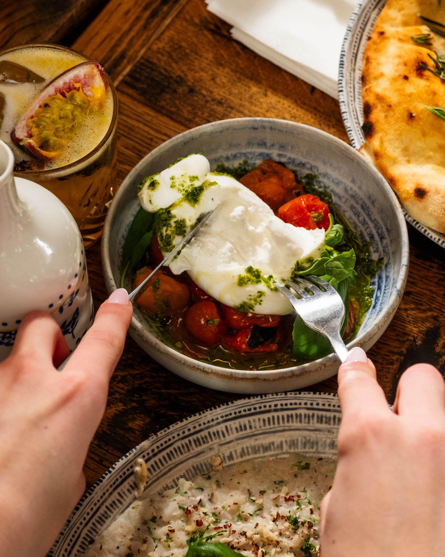 Burrata qui s'ouvre sur des tomates, plat typique italien.