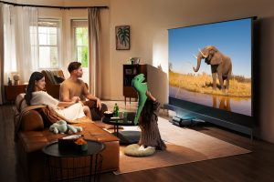 Famille regardant un film avec le vidéoprojecteur 4K JMGO O2S Ultra projetant un éléphant sur grand écran dans le salon
