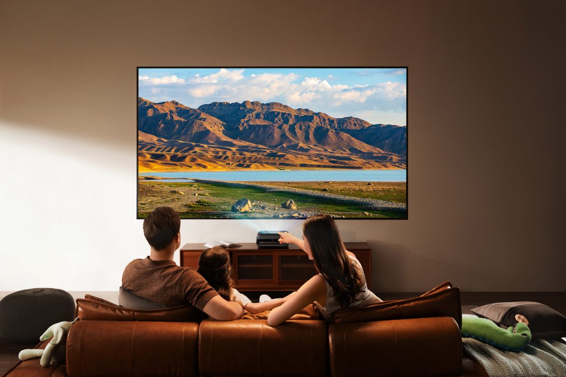 Famille regardant un film projeté par le vidéoprojecteur 4K JMGO O2S Ultra dans un salon moderne