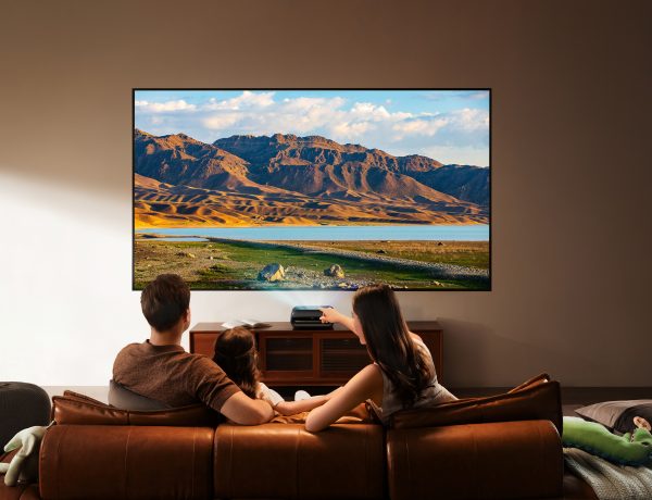 Famille regardant un film projeté par le vidéoprojecteur 4K JMGO O2S Ultra dans un salon moderne