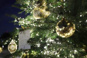 Une carte de vœux Magic Tales accrochée au sapin du Domaine Reine Margot Paris Issy, symbole de la magie des fêtes.
