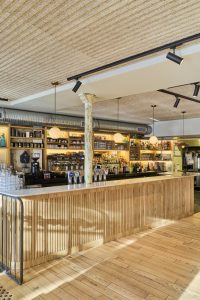 Bar du restaurant Moncoeur Belleville avec comptoir en bois clair et ambiance conviviale à Paris