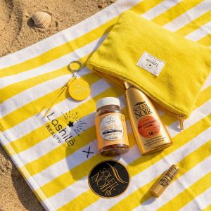 Lashilé Beauty x Soleil noir, contenu coffret étalé sur serviette rayé