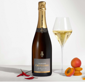 Champagne Castelnau Solera 9.3 avec du piment et de l'abricot disposés autour.